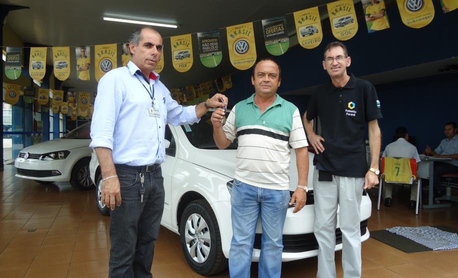 Agente de crédito Reinaldo Ribeiro acompanha os taxistas Estevan Cezar de Oliveira e Rosinei Veronez de Aguiar ao receberem as chaves dos novos veículos.