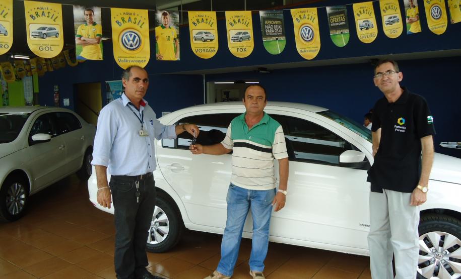 Agente de crédito Reinaldo Ribeiro acompanha os taxistas Estevan Cezar de Oliveira e Rosinei Veronez de Aguiar ao receberem as chaves dos novos veículos.