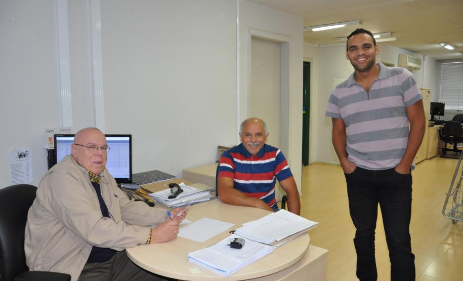 Os taxistas Genésio Vicente e Jeferson Vicente, pai e filho, foram os primeiros a conseguir contratar um financiamento da linha Banco do Empreendedor Taxistas, da Fomento Paraná, que foi reaberta em maio, por determinação do governador Beto Richa. Na imagem, os dois com o gerente de microcrédito da Fomento Paraná, Hélio Rodrigues.