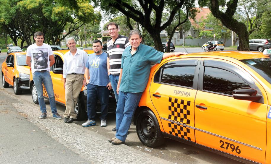 Fomento Paraná cumpre meta de financiamento de táxis para 2015 Os taxistas Artur e Márcio Ergang, com carros financiados pela linha Banco do Empreendedor Taxistas, da Fomento Paraná, junto com colegas taxistas, em Curitiba.