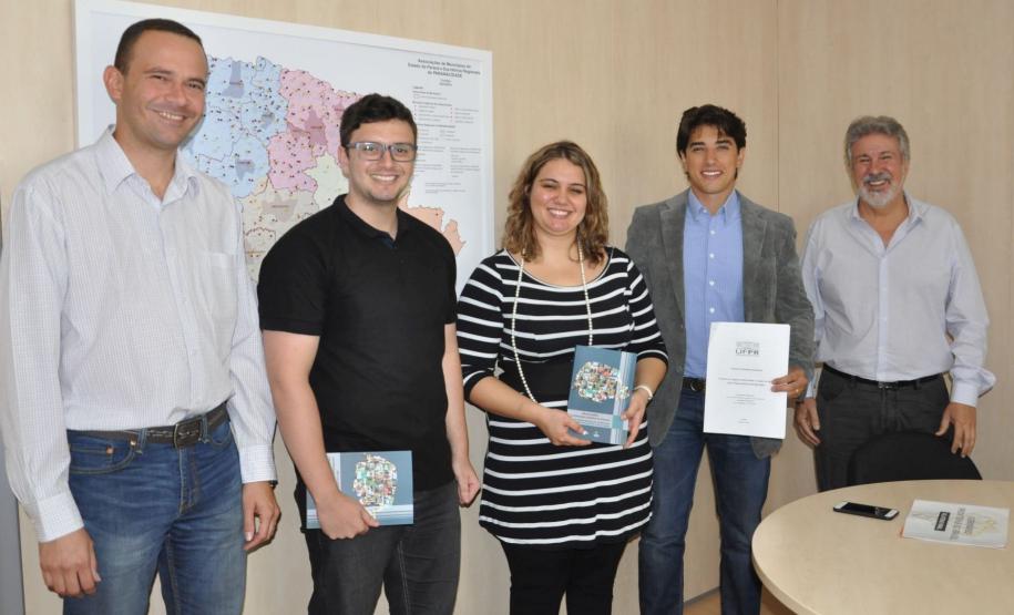 Aluno Mauro Magalhães Júnior e Prof. Dra. Raquel Rangel de Meireles Guimarães visitam a Fomento Paraná. Na imagem, os dois ladeados do analista de desenvolvimento Richer Matos, do diretor de mercado e relações institucionais Luiz Renato Hauly e do assessor Mario Figueiredo.