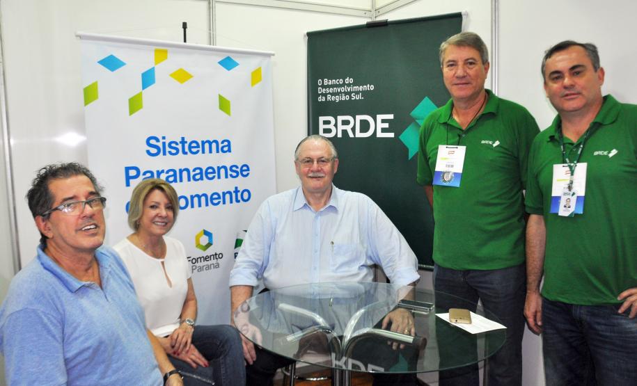 Fomento Paraná participa da Expolondrina. 
Na foto, Emília Belinati, assessora da Fomento Paraná, o diretor Administrativo do BRDE, Orlando Pessuti, e técnicos do banco, no estande compartilhado.