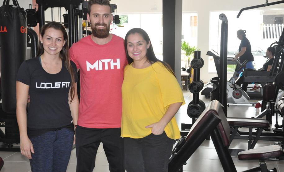 A profissional de educação física buscou financiamento da Fomento Paraná para montar a academia, inaugurada em maio de 2017. Na imagem, com o noivo Thiago Cogo e com a agente de crédito Karoline Hoffmann.