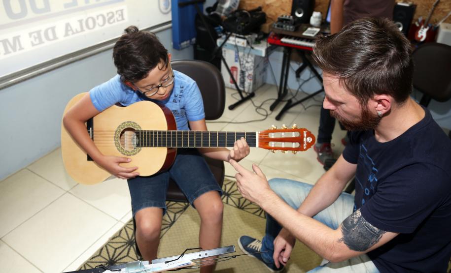 O professor Rodrigo Haniskievicz orienta o aluno Alexandre Pinheiro Neto. Local atende estudantes de música de todas as idades. Empreendedor usou a linha da Fomento Paraná, desenvolvida em parceria com a Secretaria de Estado da Cultura para apoiar empreendimentos da economia criativa.