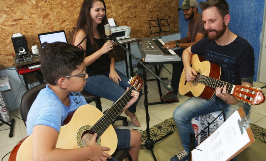 Escola de Palmeira atende estudantes de música de todas as idades. Empreendedor usou a linha da Fomento Paraná, desenvolvida em parceria com a Secretaria de Estado da Cultura para apoiar empreendimentos da economia criativa. Na imagem, os alunos Alexandre Pinheiro Neto e Paloma de Jesus Cubas com o professor Rodrigo Haniskievicz e Webis Duarte (ao fundo).